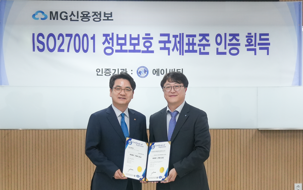 MG Credit Information Service CEO Park Joon-chul, left, poses after receiving the ISO 27001 certification plaque at the company’s head office in Seoul on Nov. 11. [Photo courtesy of KFCC]