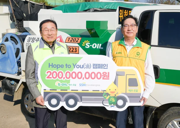 S-OIL Director Seo Jeong-gyu, right, poses after delivering a contribution to KNCSW Chairman Kim Sung-yi in Seoul on Nov. 19. [Photo courtesy of S-Oil]