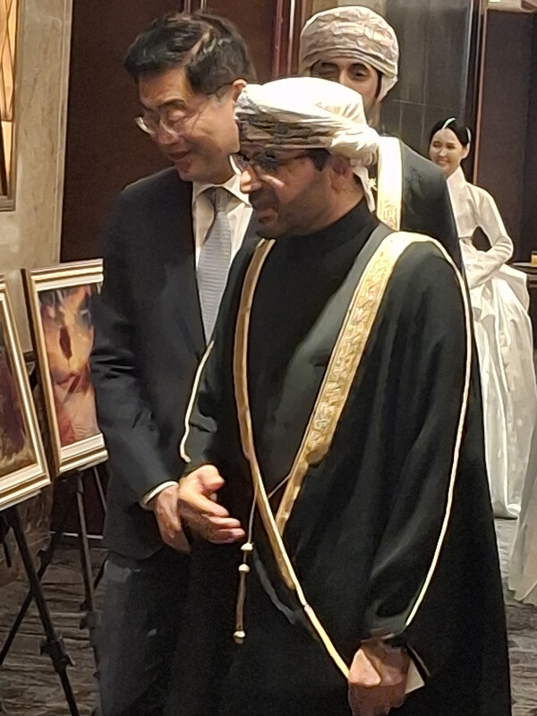 Oman Amb. Zakariya Al Saadi, right, is ushering Ministry of Foreign Affairs Deputy Minister for Public Affairs Lee Jae-woong during a recent diplomatic reception in Seoul. [Photo courtesy of Embassy of Oman]